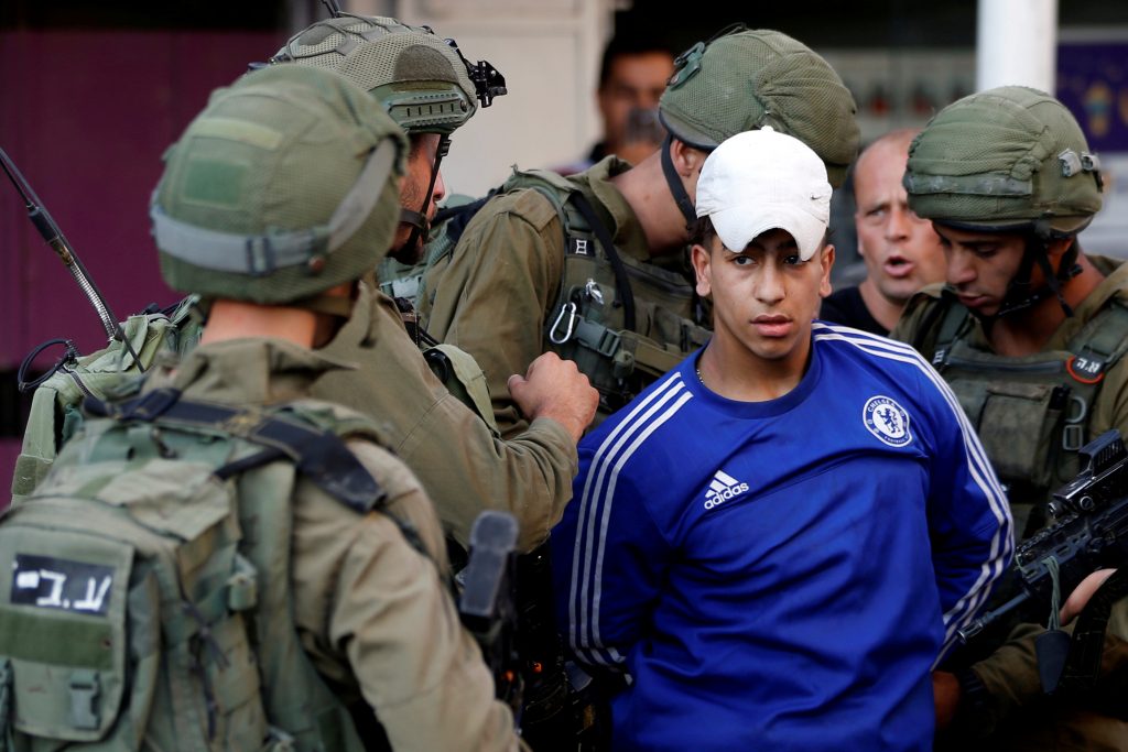 يحتجز الجنود الإسرائيليون فلسطينياً أثناء احتجاج ضد خطة السلام الأمريكية في الشرق الأوسط ، في الخليل ، في الضفة الغربية التي تحتلها إسرائيل