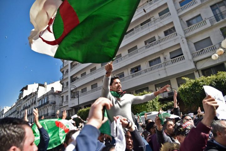 الجزائريون يهتفون بالشعارات ويلوحون ويلوحون بالأعلام بعد إسقاط رئيسهم عبدالعزيز بوتفليقه/ رويترز 