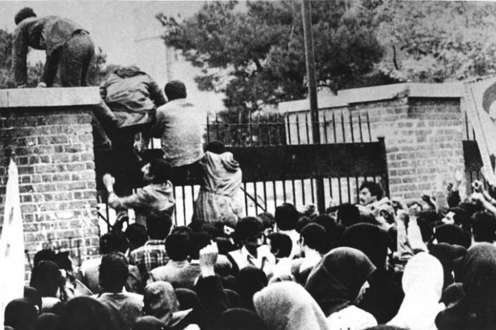 طلاب إيرانيون يصعدون بوابة مدخل السفارة الأمريكية في طهران في 4 نوفمبر 1979/ AFP