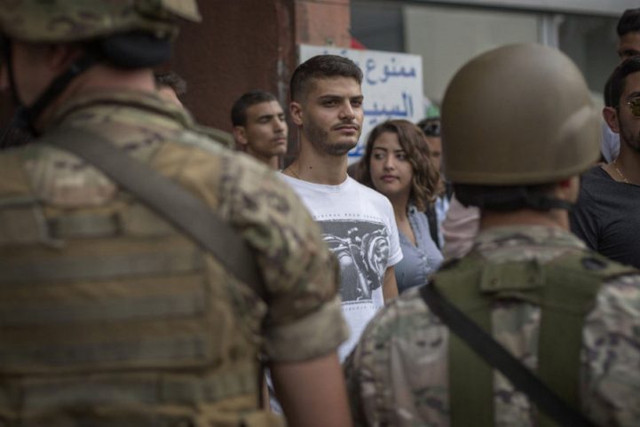 متظاهرون لبنانيون يقفون أمام الجيش خلال الاحتجاجات وسط بيروت/ Getty