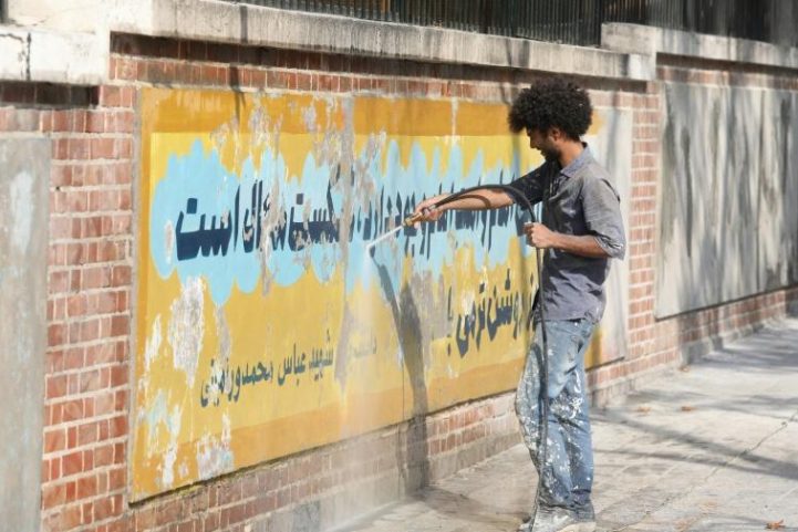 إيراني يمحو في 29 سبتمبر 2019 لوحة جدارية مرسومة على جدران السفارة الأمريكية في طهران للاحتفال بخطف الرهائن الدبلوماسيين الأمريكيين في عام 1979/ AFP