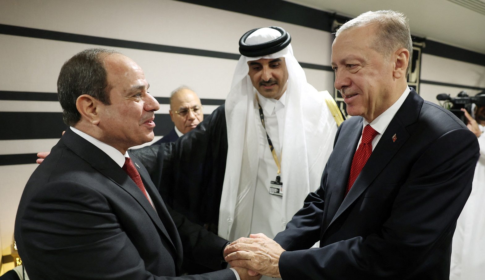 الرئيس التركي رجب طيب أردوغان يصافح نظيره المصري عبد الفتاح السيسي في قطر - رويترز