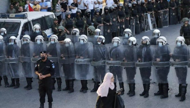 <strong>عناصر من قوات الأمن التابعة للسلطة الفلسطينية يغلقون طريقًا بينما يتظاهر المتظاهرون في رام الله بالضفة الغربية المحتلة</strong><br>