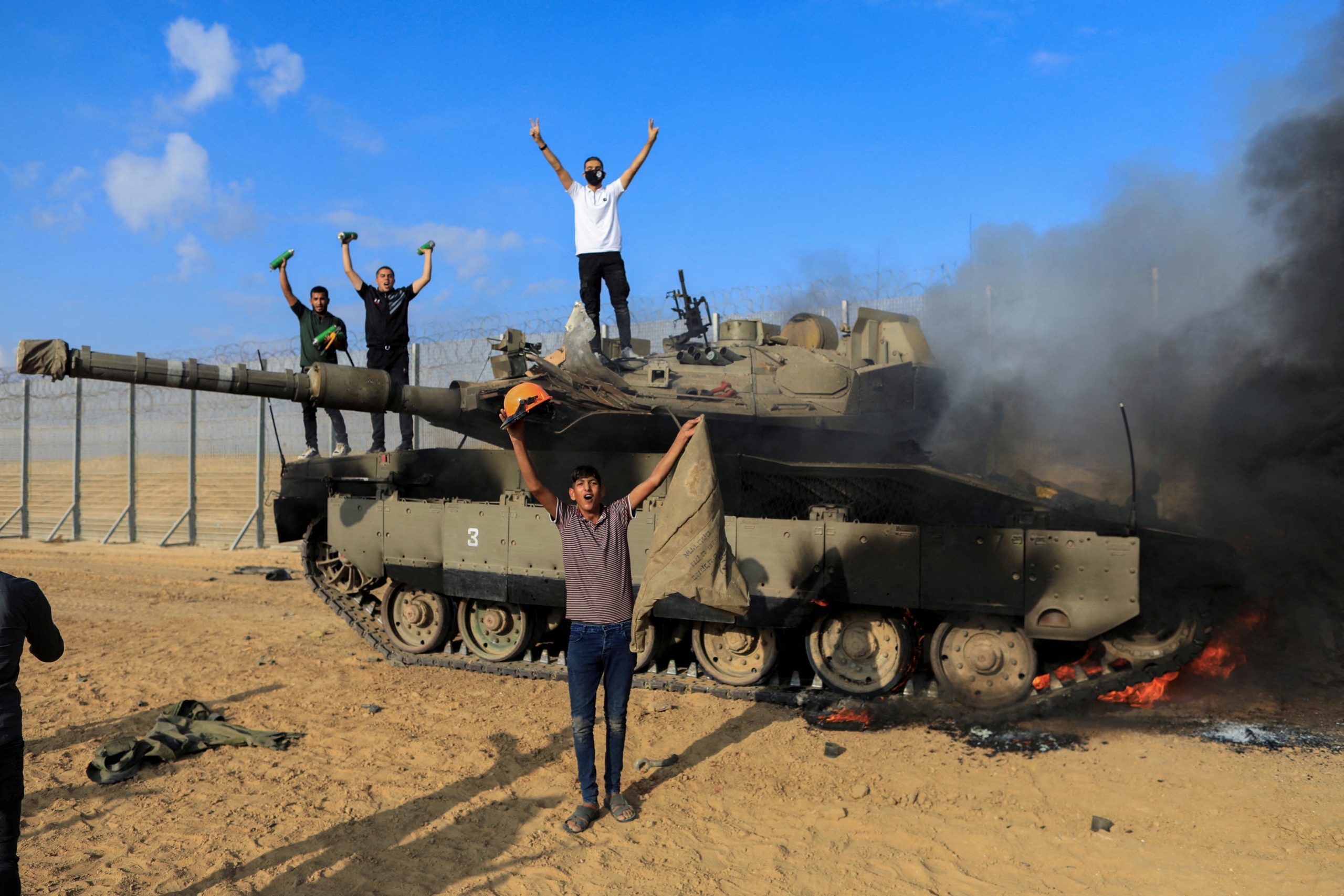 فلسطينيون يحتفلون فوق دبابة إسرائيلية/ رويترز