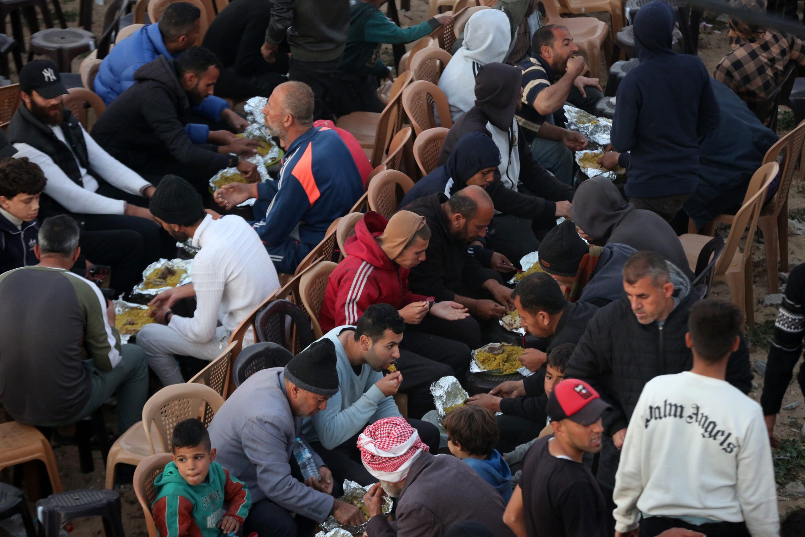 عائلات فلسطينية تتناول طعام الإفطار الجماعي لأول يوم من رمضان على أنقاض منازل دمرتها إسرائيل-الأناضول
