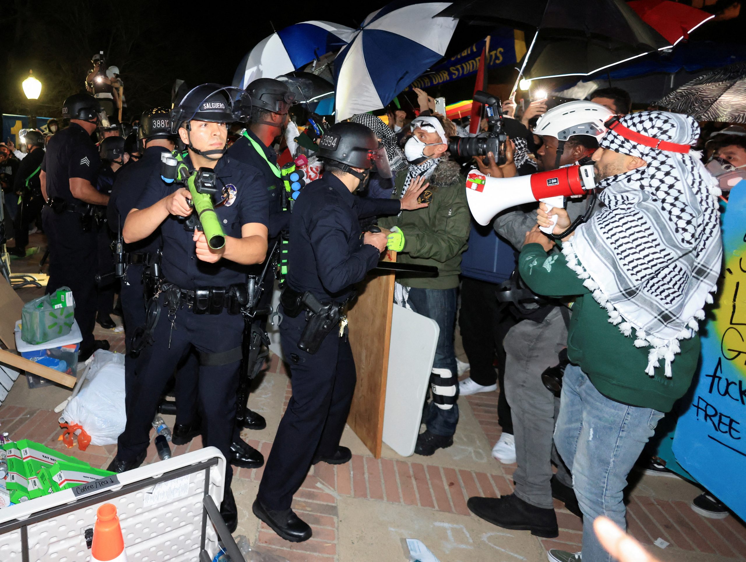 ضباط شرطة إنفاذ القانون يدخلون مخيم احتجاج مؤيد للفلسطينيين في جامعة كاليفورنيا في لوس أنجلوس في 2 مايو/آيار 2024-رويترز